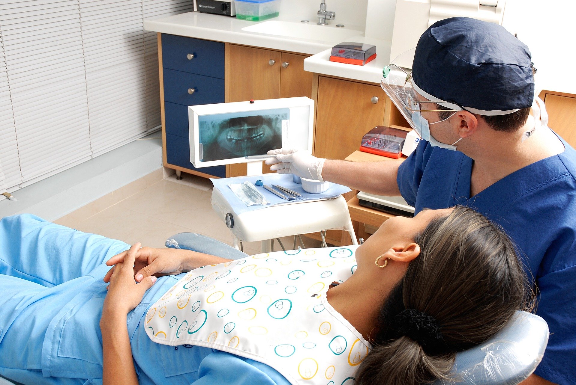 A dentist installing a dental prosthesis to a patient